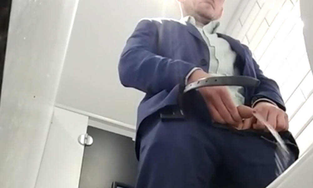 guy in suit caught peeing in public toilet
