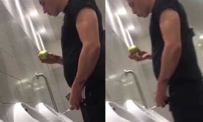 guy peeing at urinal while eating apple