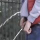 two friends pissing in public after football game