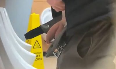 Handsome man squeezing and shaking his dick at urinals