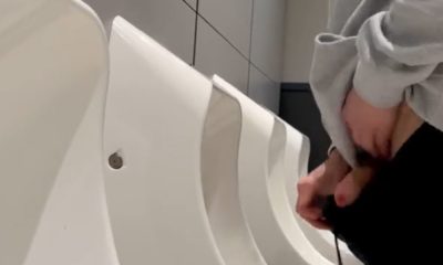 Ginger guy shaking his dick after peeing at the urinals