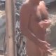 Some men naked at the beach showers