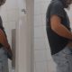 Spying long haired man taking a pee at urinals