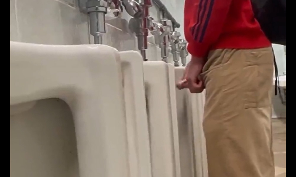 Guy peeing and shaking his dick at airport urinals