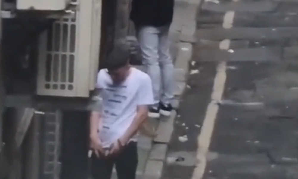 two men caught peeing in a street