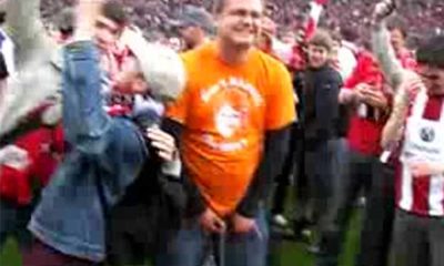 football supporter peeing on the pitch in public