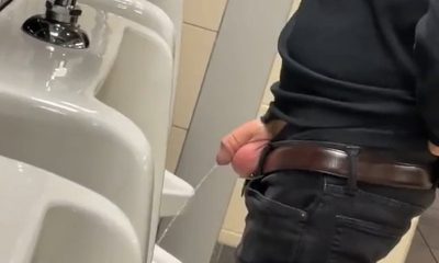 guy taking a pee at urinals with cock and balls out
