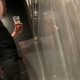 drunk guy peeing at urinals holding a glass of beer