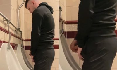 straight lad in shorts taking a pee at urinals