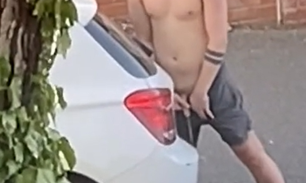 Shirtless guy caught peeing in the street